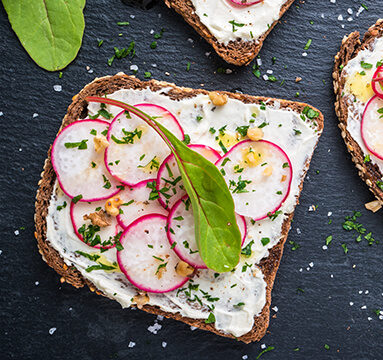 Cream cheese on toast topped with sliced radish